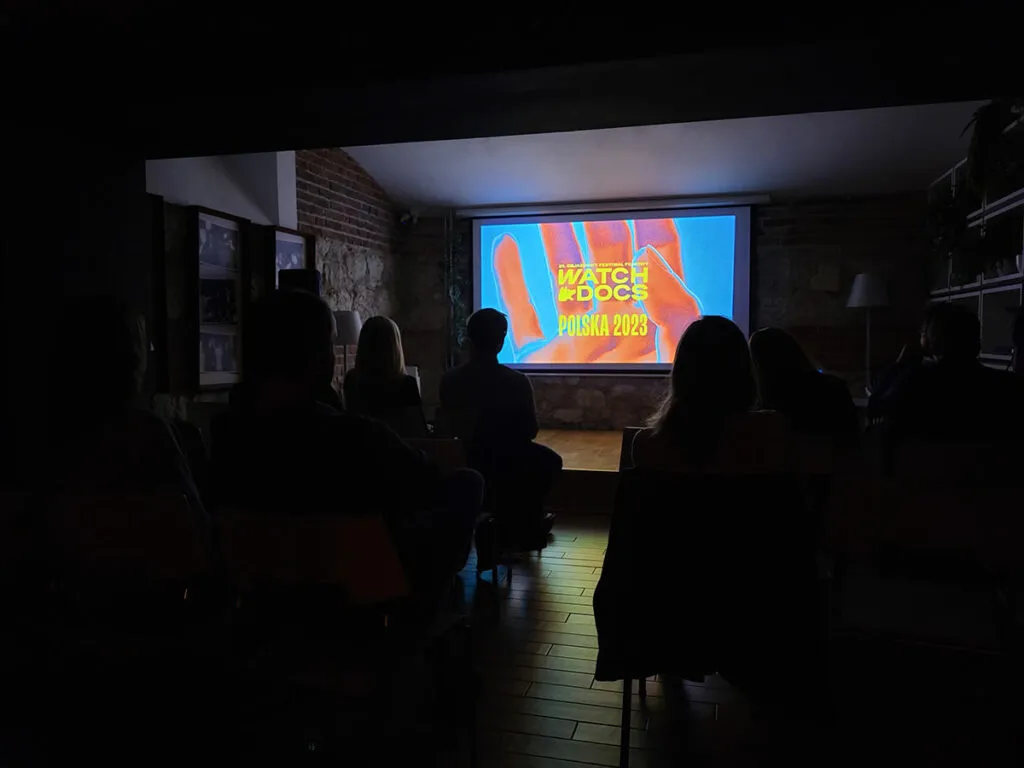 Ludzie oglądający film w ciemnej sali