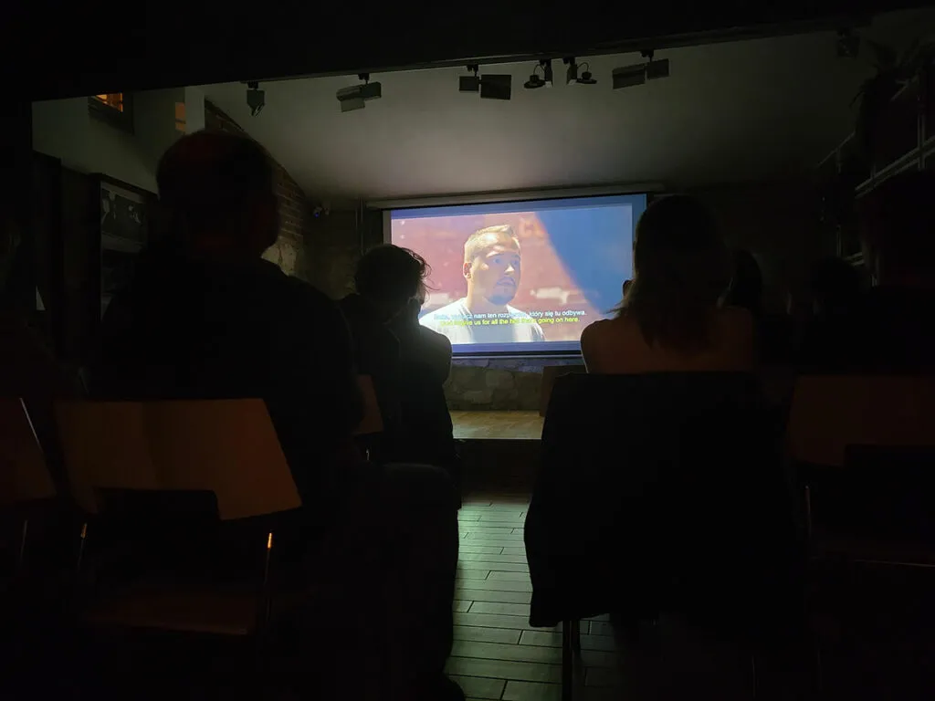 Ludzie oglądający film w ciemnej sali