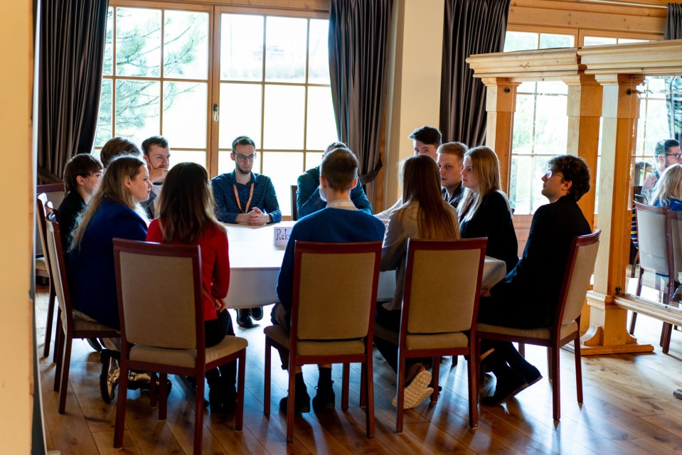 Grupa młodych ludzi siedząca przy stoliku