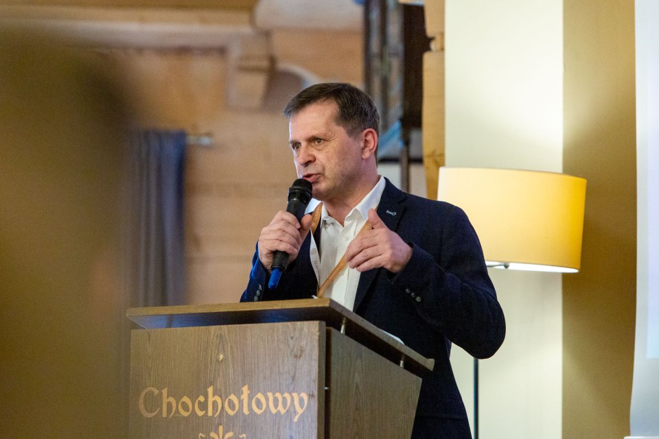 Mężczyzna w garniturze mówiący do mikrofonu